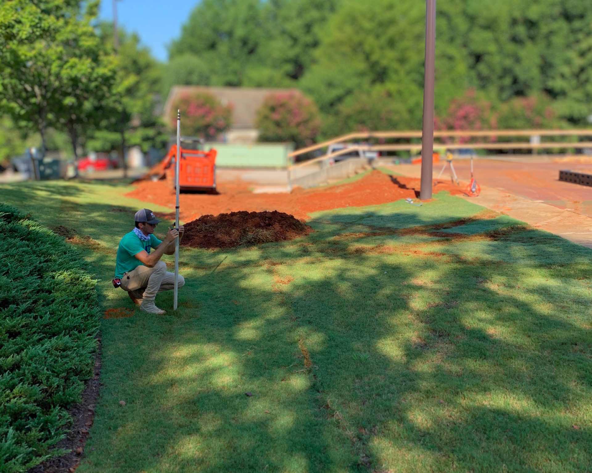 Pro Play crew member troweling a formed concrete border on a graded playground site