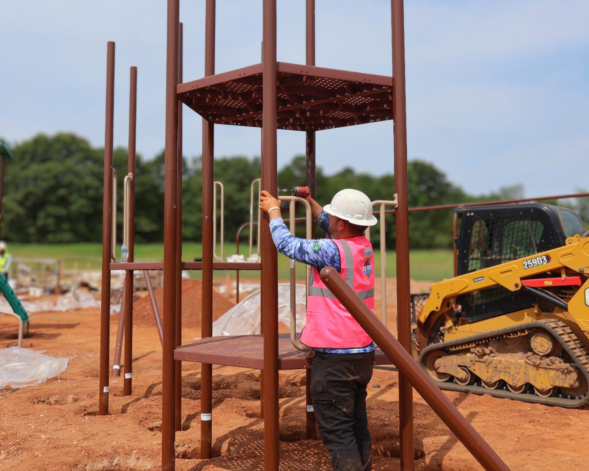 Pro Play installer bolting a deck onto the steel uprights of a new play structure