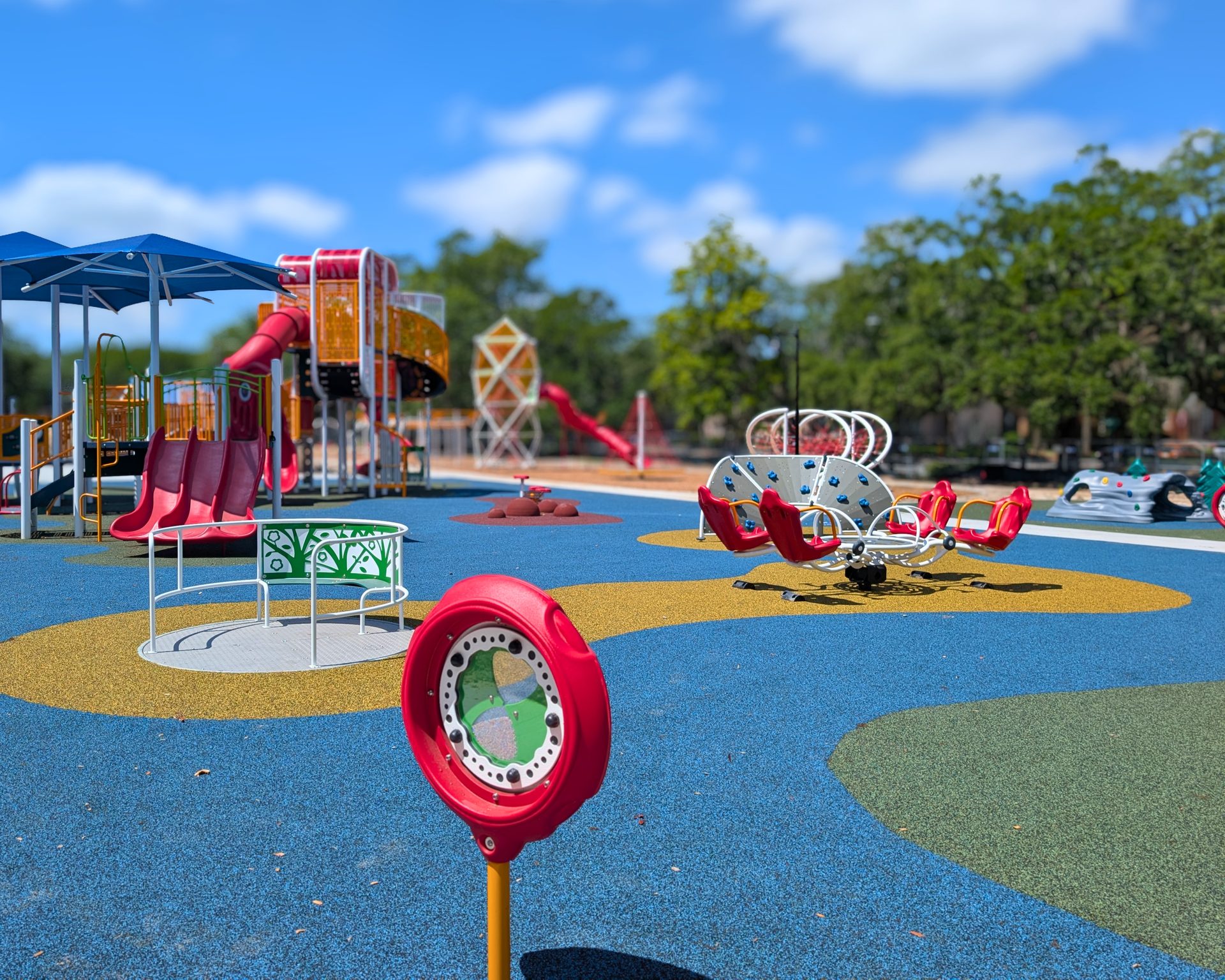 Pro Play crew member checking finished grade with a laser level rod at a playground site