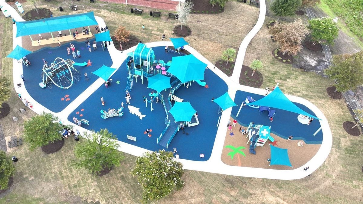 Aerial view of the ocean-themed playground at Carolina Forest Rec, with teal sail shades over navy poured surfacing