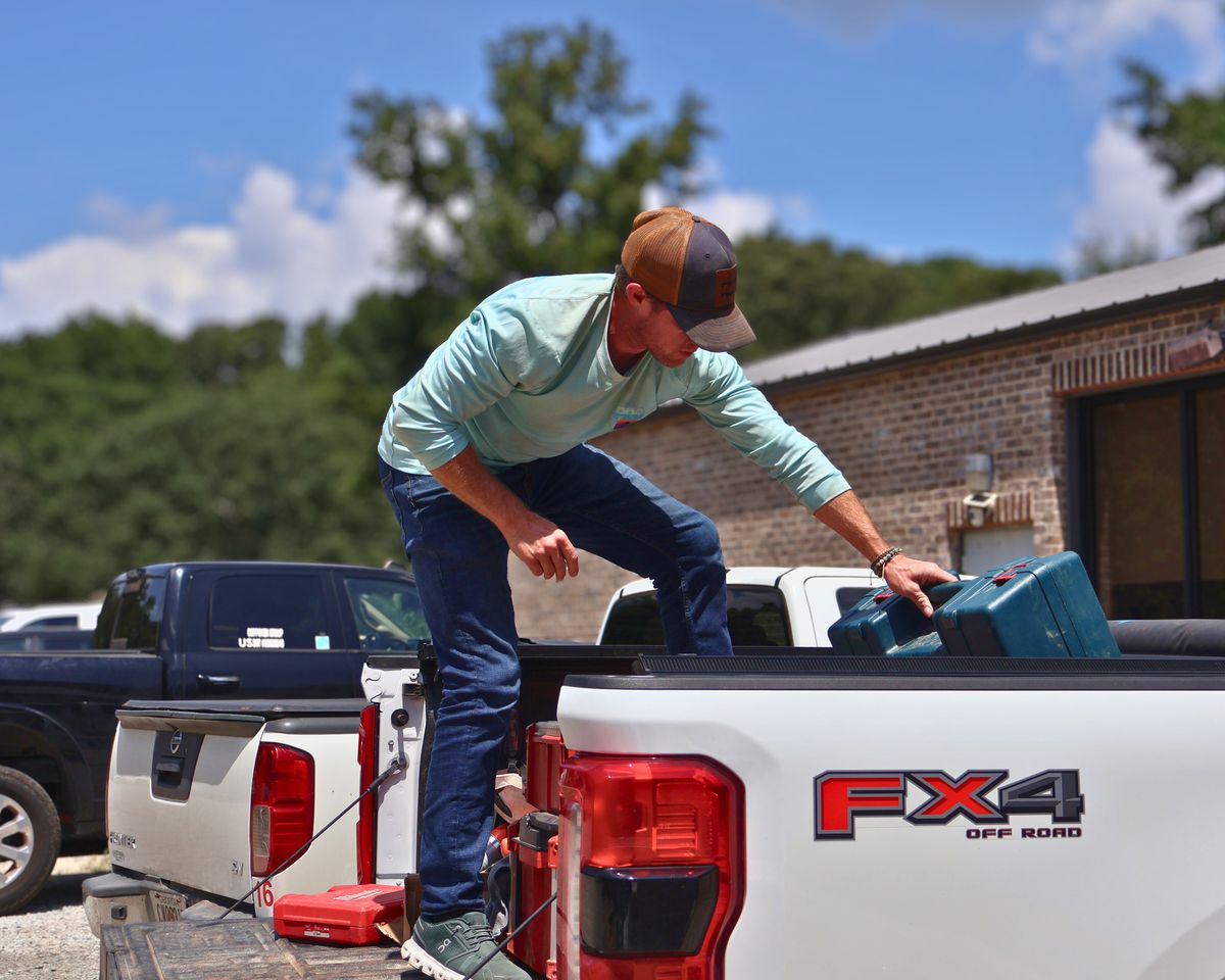 Pro Play crew member loading tool cases into a pickup truck bed
